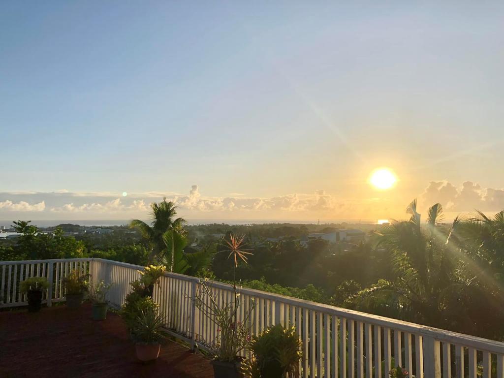 - une vue sur le coucher du soleil depuis le balcon d'une maison dans l'établissement Apaula Heights Lounge, à Apia