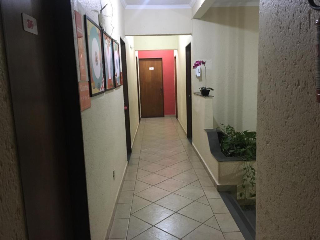 a hallway with a red door and a tile floor at HOTEL CENTER Ribeirão in Ribeirão Preto