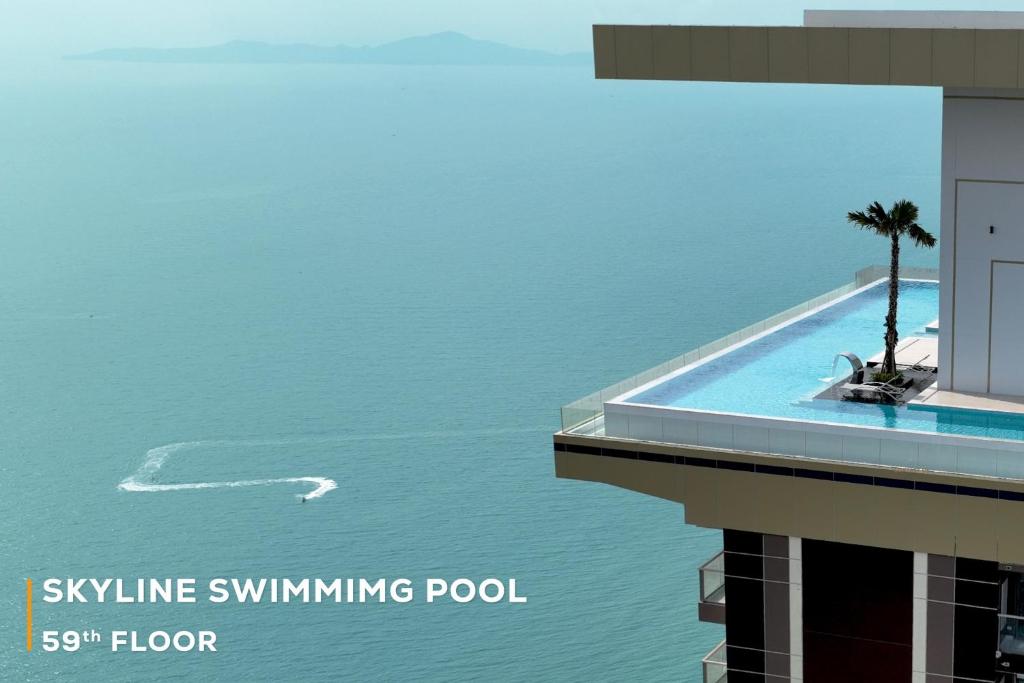 a swimming pool in the water next to a building at Copacabana Beach Jomtien in Jomtien Beach