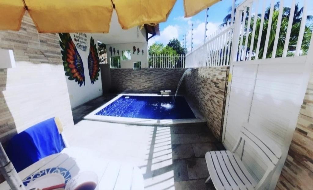 een klein zwembad in een patio met een parasol bij Porto de Galinhas - Casa PortoMar - 3 quartos - 14 hóspedes - com Piscina - 185m in Porto De Galinhas