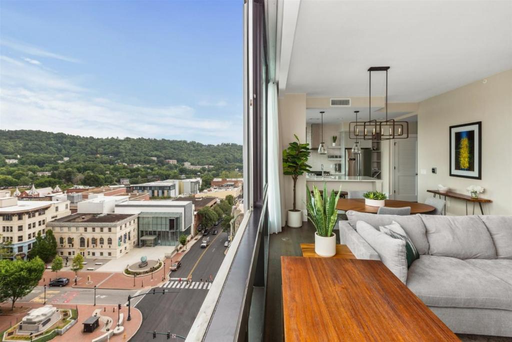a living room with a couch and a view of a city at 'Cloud 10' A Luxury Downtown Condo with Panoramic City and Mountain Views at Arras Vacation Rentals in Asheville