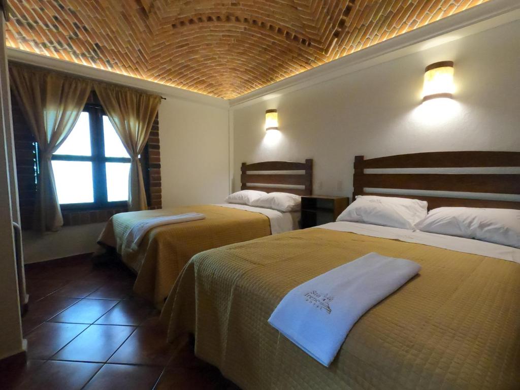 Cette chambre comprend 2 lits et une fenêtre. dans l'établissement Hotel Santa Irene, à Cholula