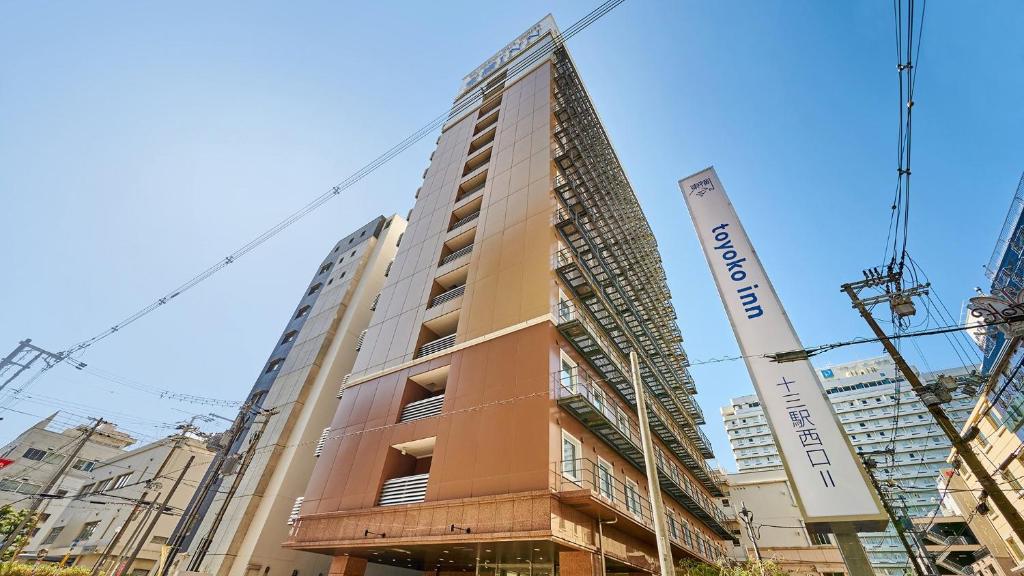 un edificio alto en construcción en una ciudad en Toyoko Inn Osaka Hankyu Juso-eki Nishi-guchi No.2, en Osaka