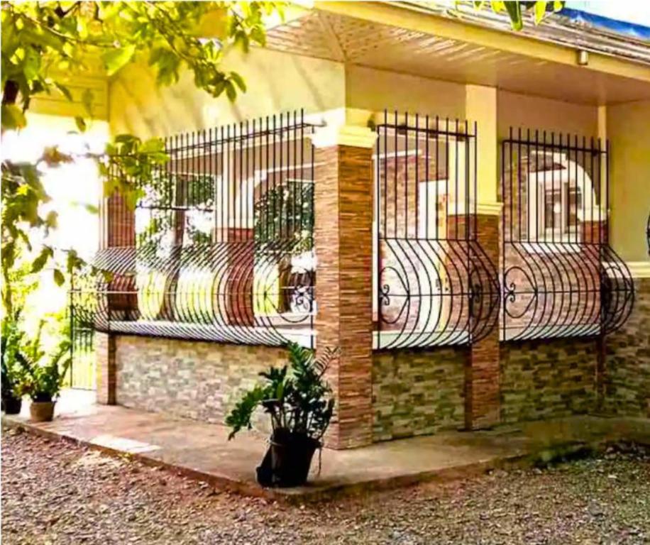 una casa con una recinzione con una pianta di fronte di Velasquez Farmhouse/Affordable Holiday Rental Near Hundred Islands 