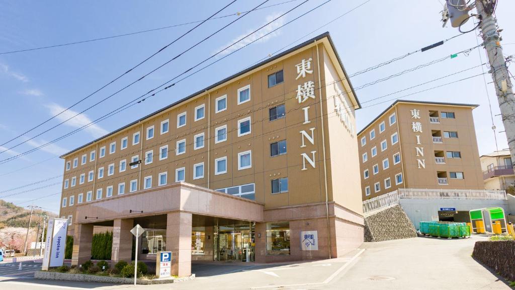 un grand bâtiment avec un écriture sur son côté dans l'établissement Toyoko Inn Fuji Kawaguchiko Ohashi, à Fujikawaguchiko