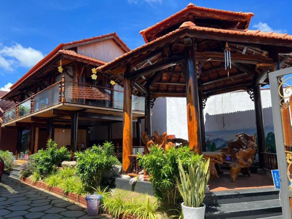 een huis met een houten dak bij Homestay Lê Gia in Xuyên Mộc