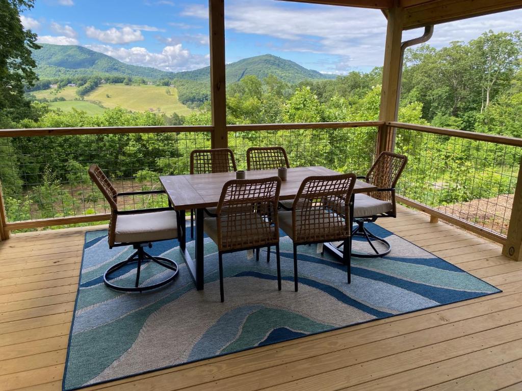 una mesa de comedor y sillas en una terraza con vistas en Blue Sky Cabin - Built in 2023 this 3 bed 2,5 bath home has gorgeous views en Jefferson