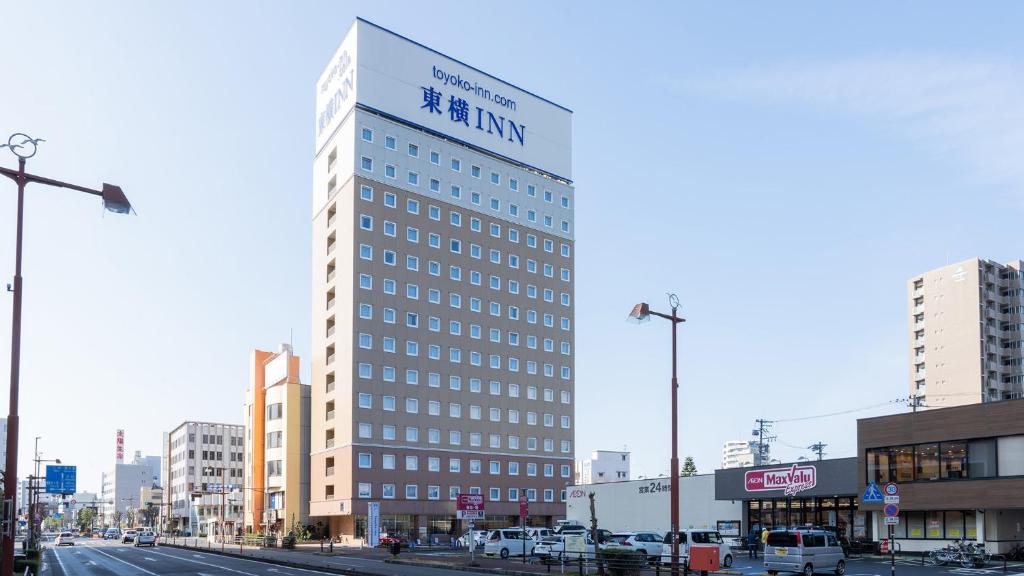 un grand bâtiment avec un panneau sur son côté dans l'établissement Toyoko Inn Shizuoka Shimizu Ekimae, à Shizuoka