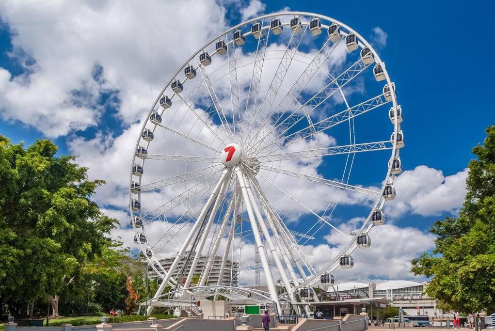 a large ferris wheel in a park under a cloudy sky at South Bank Central 1 bedroom apartment with Parking in Brisbane