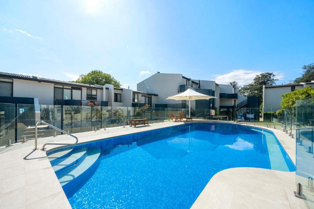 a large swimming pool in front of a building at Manuka Park Serviced Apartments in Canberra