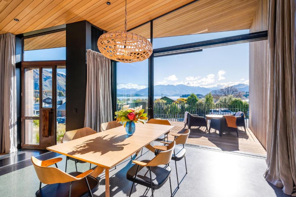 ワナカにあるHideaway on Warren by Sotheby's Luxury Rental Homesのテーブルと椅子と大きな窓のあるダイニングルーム