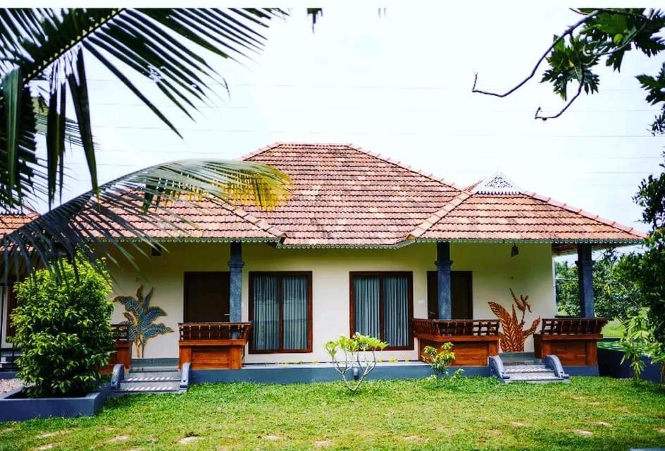 a house with benches in front of it at KOTTACKAL NATURE INN in Angamaly