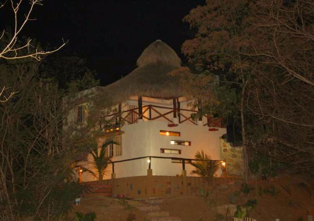a large white building at night with trees at Casa Andivi, Placer sin fin in San Pedro Pochutla