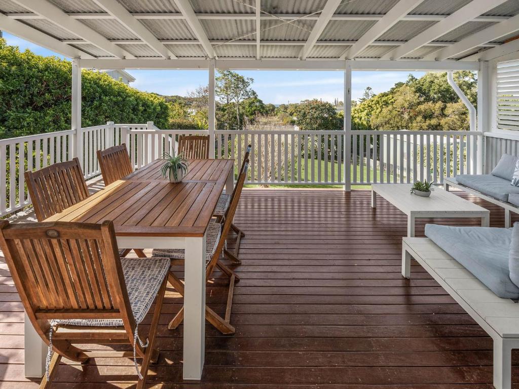 een terras met een houten tafel en stoelen bij 15 Seaview Terrace Moffat Beach QLD in Caloundra