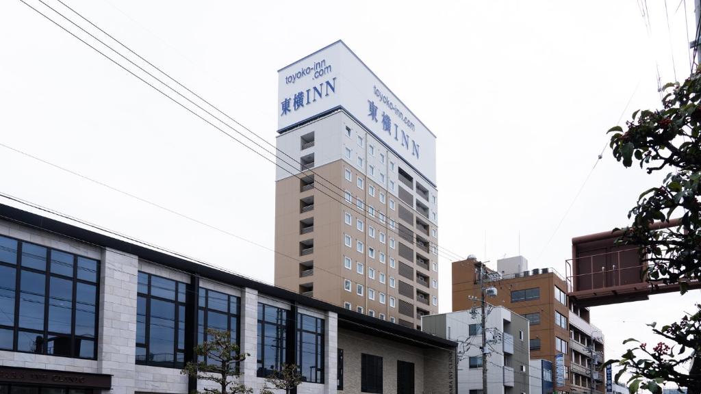 a tall building with a sign on top of it at Toyoko Inn Shizuoka eki Minami guchi in Shizuoka
