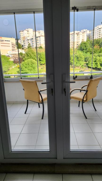 a room with two chairs and a table and windows at Arya home 18 in Trabzon