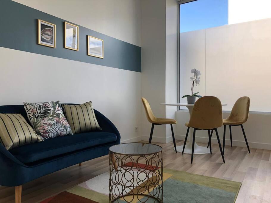 een woonkamer met een blauwe bank en een tafel bij Studio Armorique - commerces in Brest