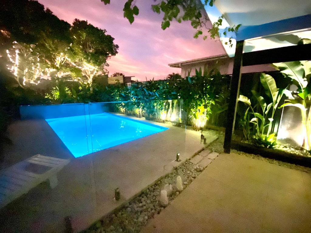una piscina in un cortile posteriore di notte di Casuarina Beach 4 bedroom home a Casuarina