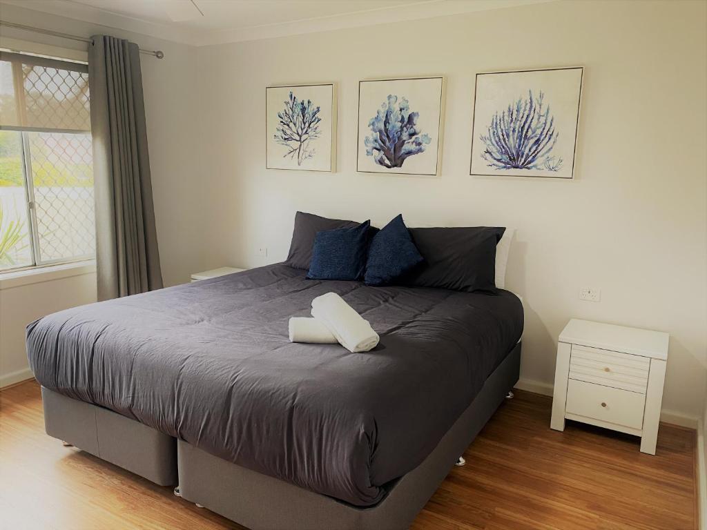 1 dormitorio con 1 cama grande con almohadas azules en Blue Tides Accommodation en Esperance