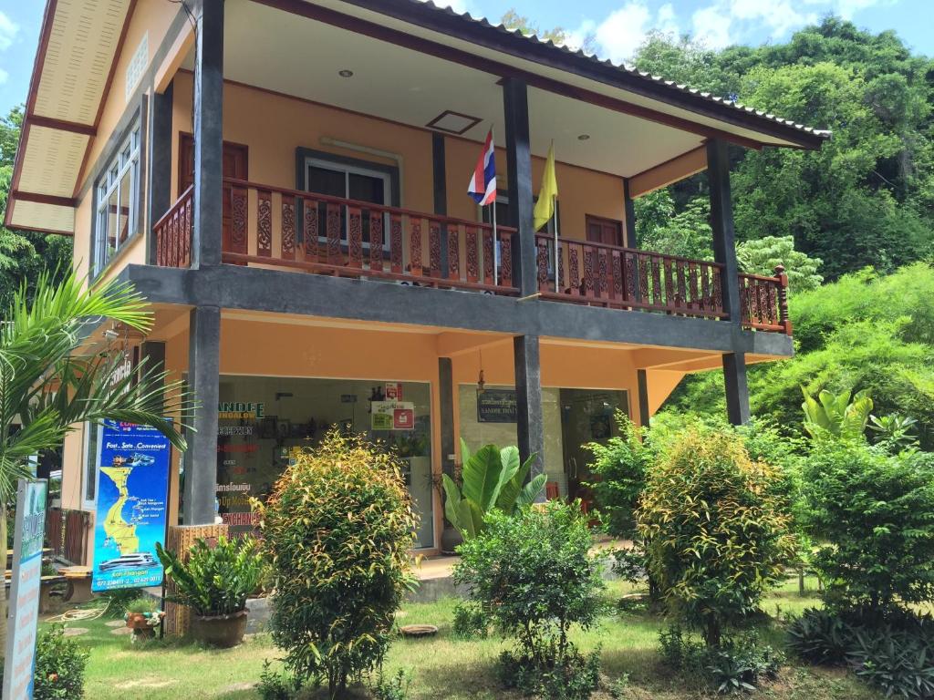 a building with a balcony and flags on it at Sandee Bungalow in Thong Nai Pan Noi