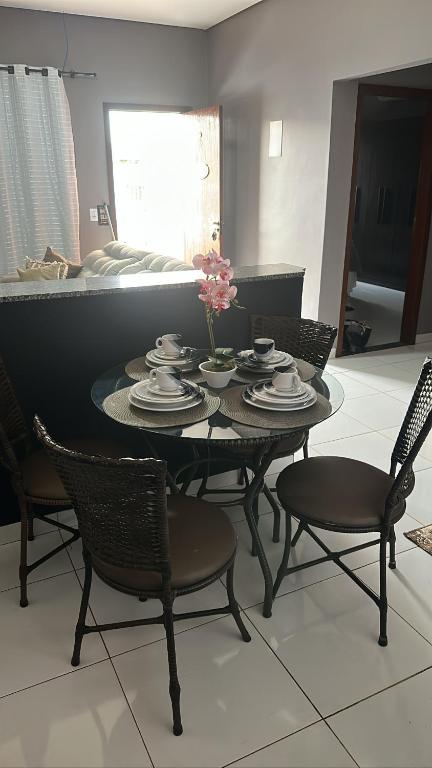 坦加拉達塞拉的住宿－Tangará da Serra，餐桌上摆放着椅子、盘子和鲜花