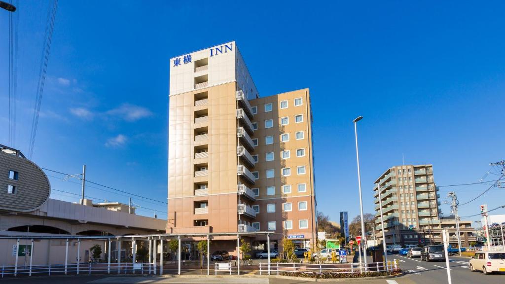 un edificio alto con un cartel encima en Toyoko Inn Tokyo Fuchu Nambu sen Minami tama Ekimae en Inagi