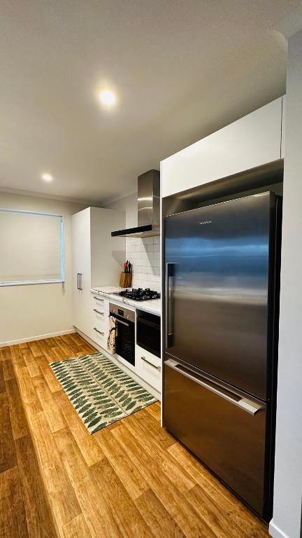 a kitchen with a stainless steel refrigerator in it at Stay with the Singhs in Rolleston