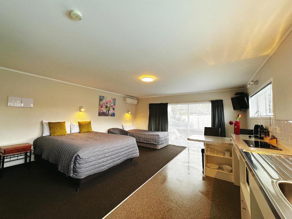 a hotel room with a bed and a sink at Continental Motel in Whangarei