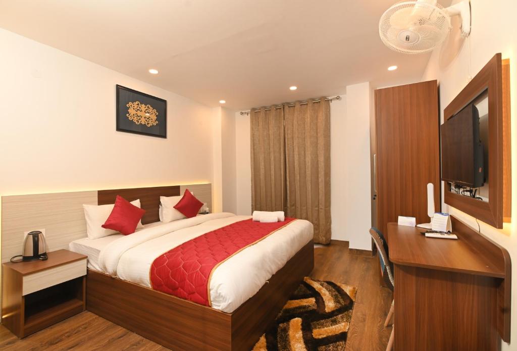 a bedroom with a bed and a desk and a television at The Altruist Business Stays , DLF Phase 3 in Gurgaon