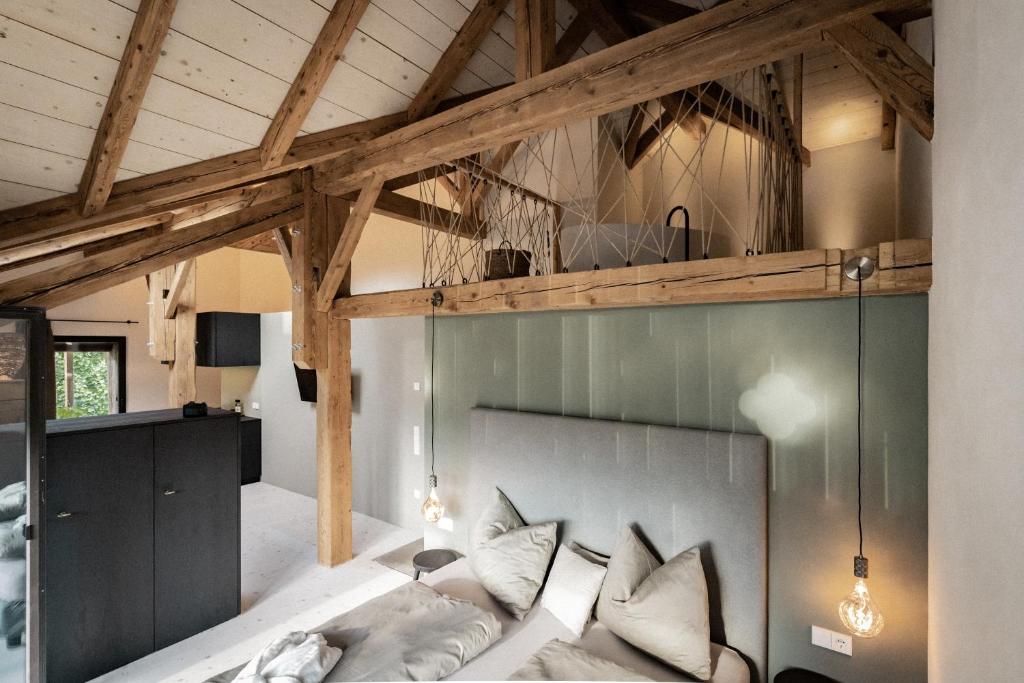 a living room with a couch and wooden ceilings at Bäcksteinerhof in Merano