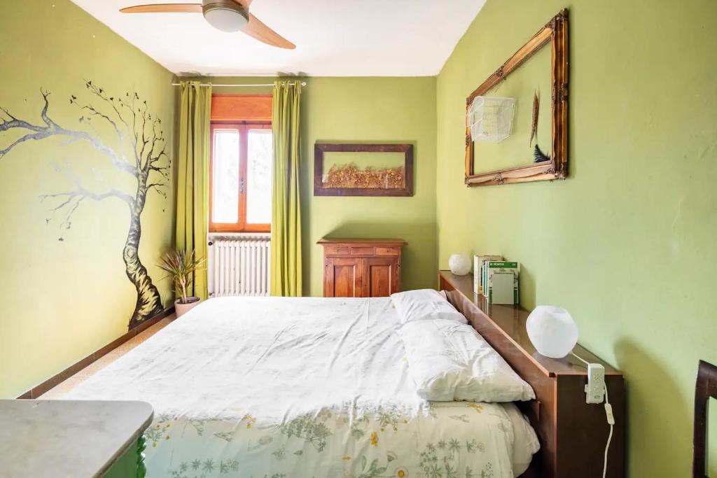 1 dormitorio con 1 cama y ventilador de techo en Selvatica50 b&b, en Nonantola