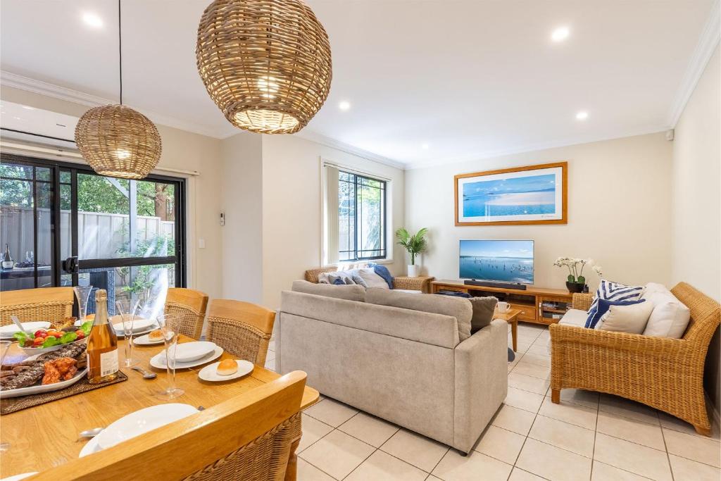 a living room with a couch and a table at 2 11a Christmas Bush Avenue - fantastic pet friendly townhouse close to Dutchies Beach with Wi-Fi and Air Con in Nelson Bay