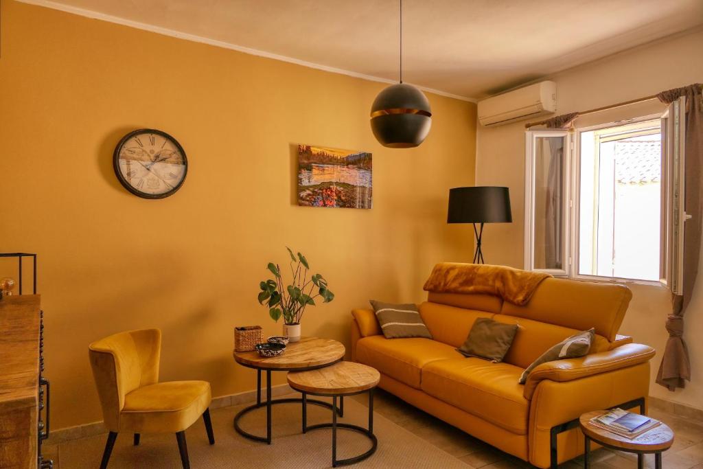 a living room with a couch and a clock on the wall at Village house of Jean in Gordes