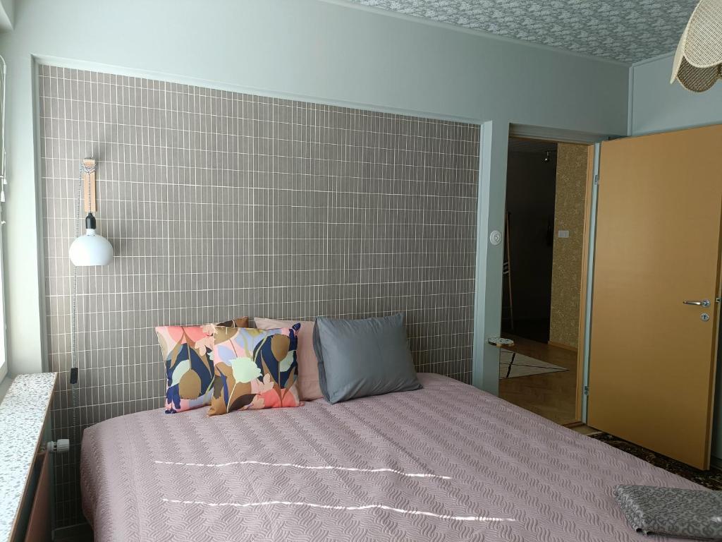 ein Schlafzimmer mit einem Bett und einer Ziegelwand in der Unterkunft Hieno kaksio keskustassa rauhallisella alueella in Lovisa