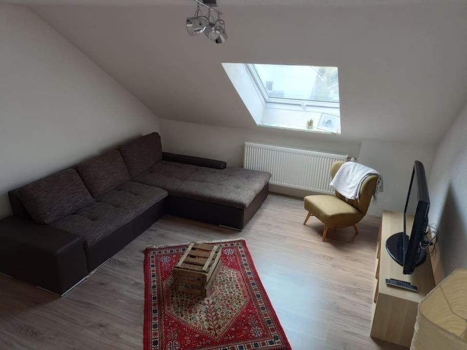a living room with a couch and a chair at Ferienwohnung - Mitten in Lauf - 2 Zimmer, große Küche in Lauf an der Pegnitz