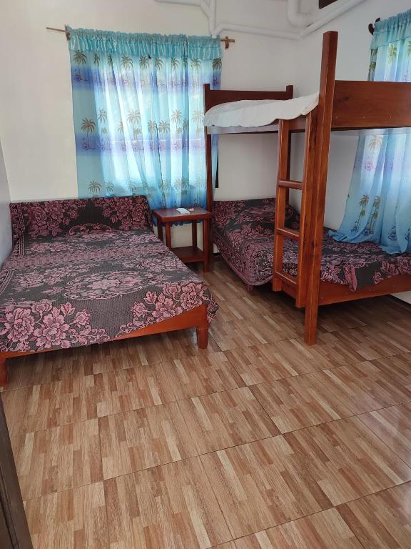 a room with two bunk beds and a wooden floor at Capul Beach Resort in Capul