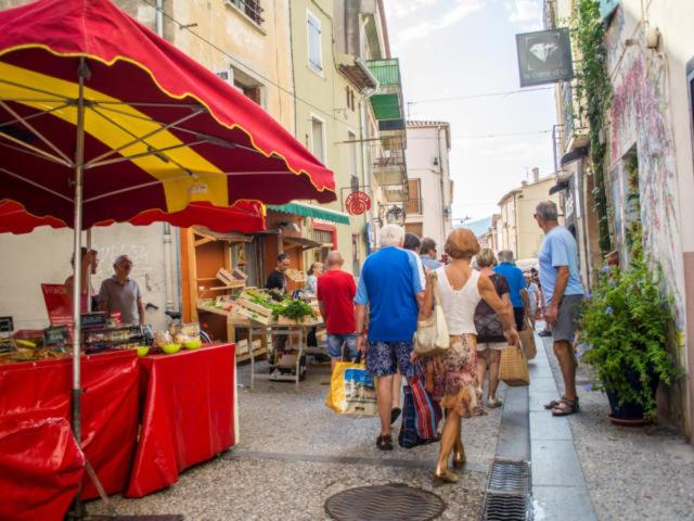 un gruppo di persone che camminano in un mercato all'aperto di Bienvenue à la plage ! ad Argelès-sur-Mer