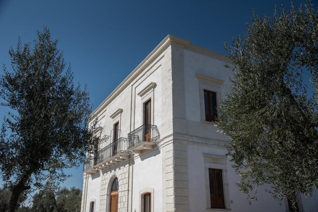 een wit gebouw met een balkon erboven bij Villa Pesce 1820 Residenza d'Epoca & SPA in Canosa di Puglia