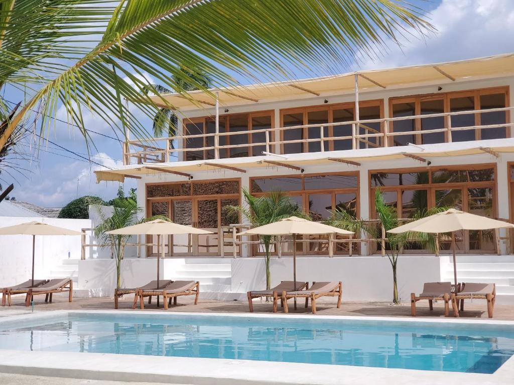 un complexe avec une piscine, des chaises et des parasols dans l'établissement Sunny Villa Matemwe, à Matemwe