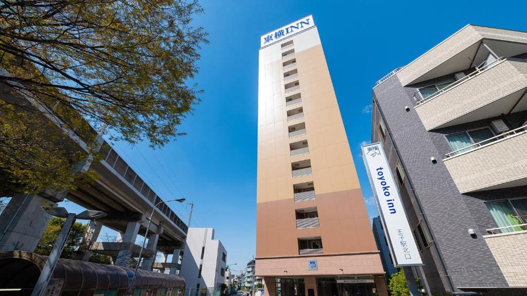 a tall building with a sign on the side of it at Toyoko Inn Tokyo Keihin Tohoku sen Oji eki Kita guchi in Tokyo