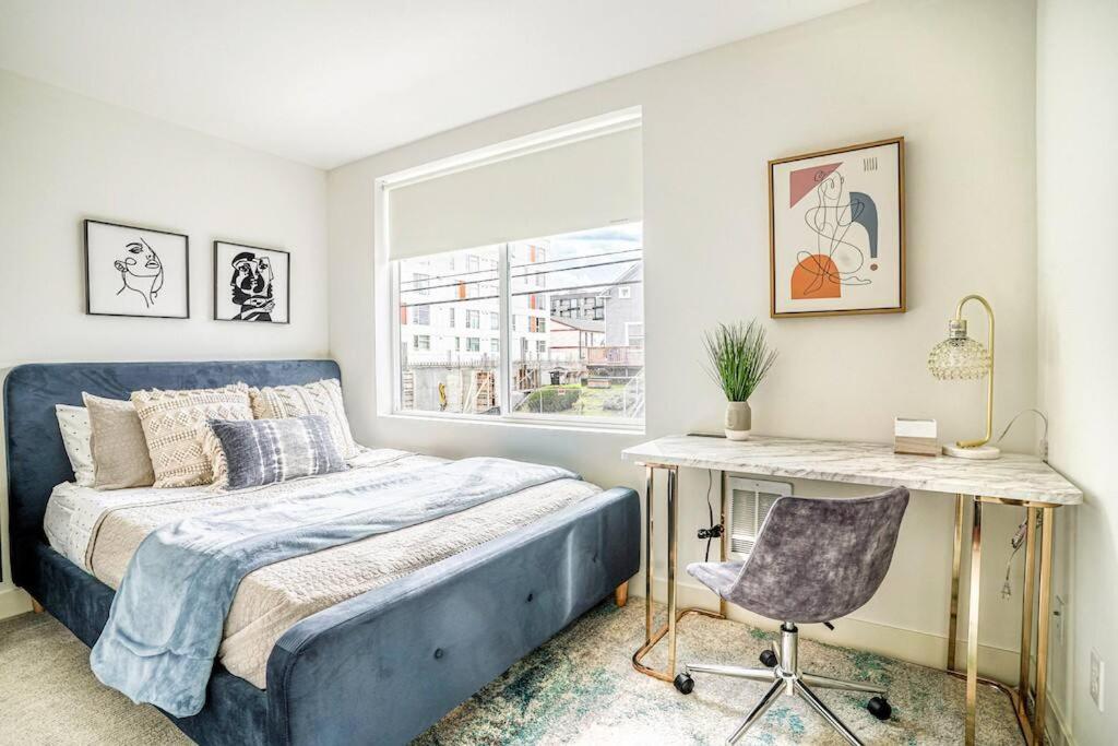 - une chambre avec un lit bleu et un bureau dans l'établissement New contemporary home, roof top deck, king bed, à Seattle