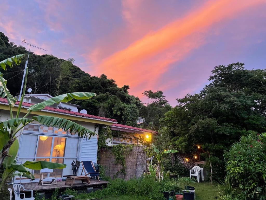 a house with a rainbow in the sky at Guesthouse Papaya in Shimoda