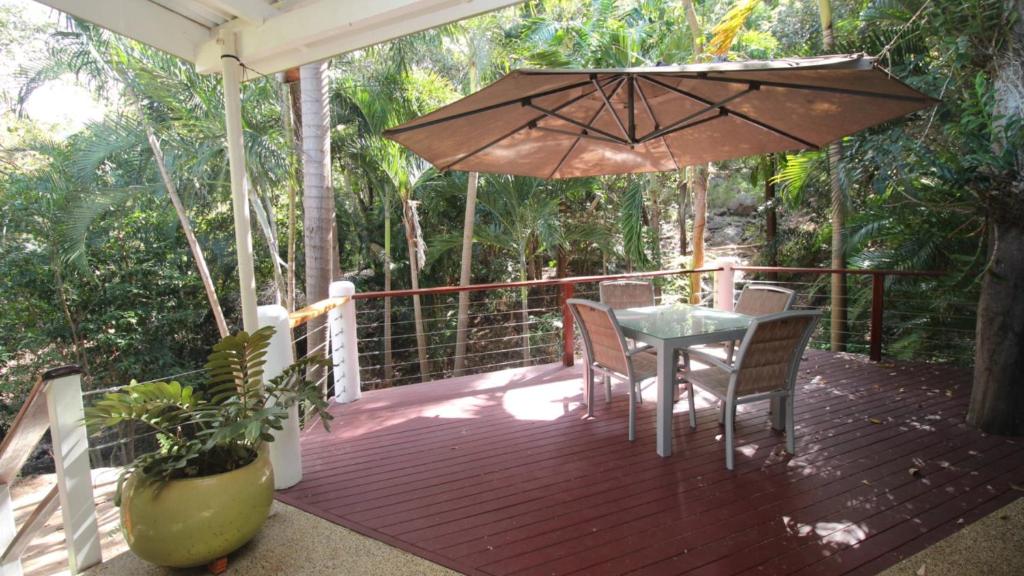 a wooden deck with a table and an umbrella at Alma Retreat in Arcadia