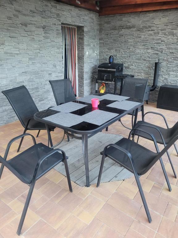 a table and four chairs in a room with a fireplace at Rodinný dom Podhájska in Podhájska