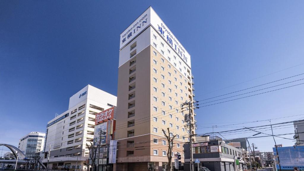 een hoog gebouw midden in een stad bij Toyoko Inn Toyota shi Ekimae in Toyota