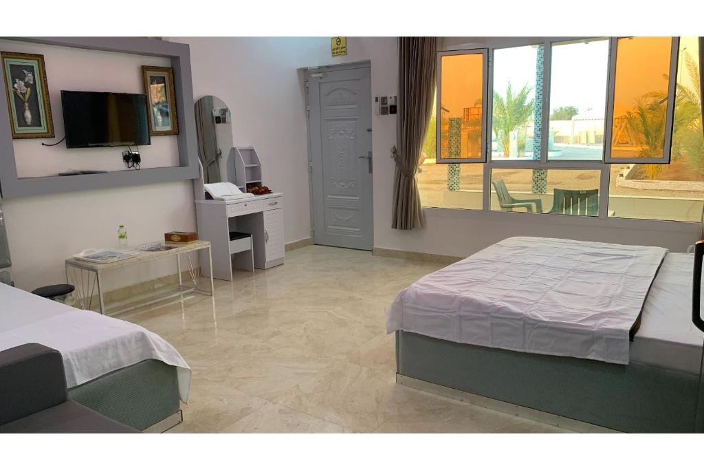 穆桑納的住宿－Super OYO 150 Reef Al Khaleej Resort，一间卧室配有一张床、一张书桌和一个窗户。