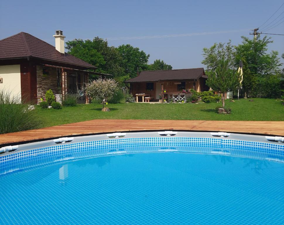 a large blue swimming pool in front of a house at Vikendica Ranč Terzić in Čačak