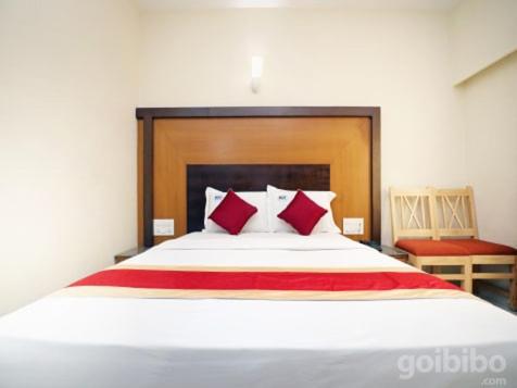 um quarto com uma cama grande e almofadas vermelhas em HLVGRANDINN em Bangalore