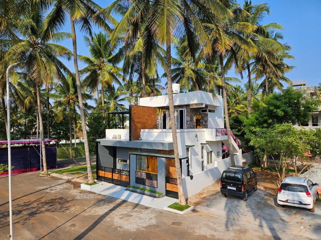 a house with palm trees in front of it at Sambhrama Grand in Mysore