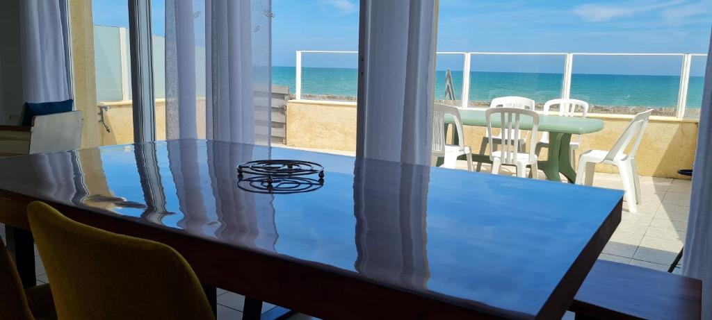 mesa de comedor con vistas a la playa en Relais des îles Saint Marcouf en Saint-Marcouf